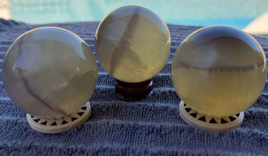 Beautiful Yellow Fluorite crystal sphere with purple banding, measuring 1.78-1.85 in / 45-47mm. Each Sphere is approximately 155-173g in weight. Stand Not Included