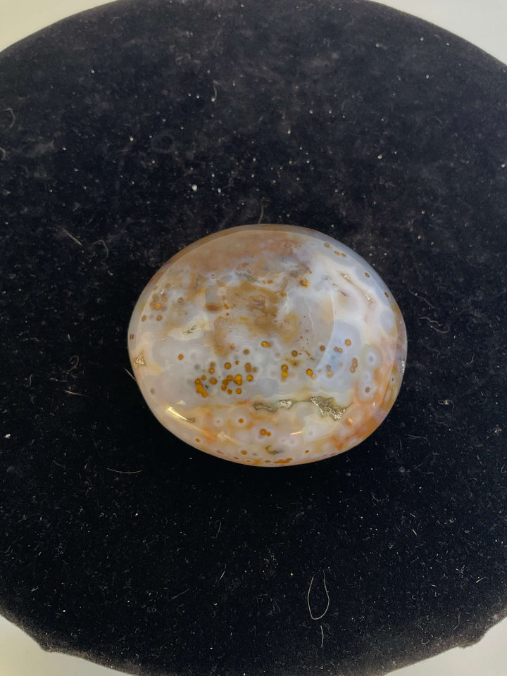 Ocean Jasper Pebble Palmstones displayed on a black background, showcasing its unique natural patterns.