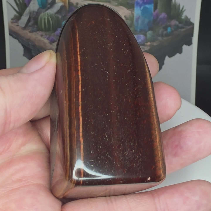 Polished Red Tiger's Eye freeform stone showcasing rich reddish-brown hues with glossy finish.