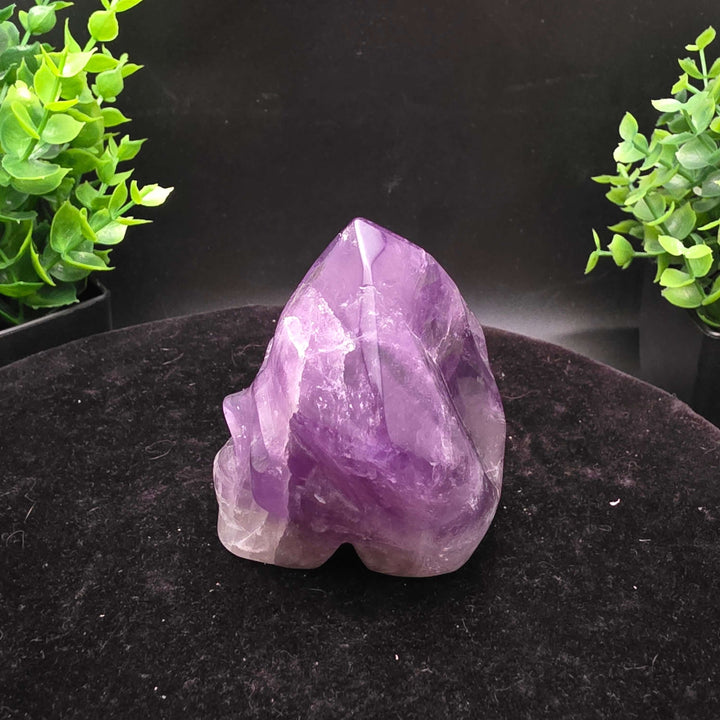 Amethyst Hand Carved Crystal Skull Wand Point Sculpture - 2.5 Inch displayed with two carved skulls and crystal points.