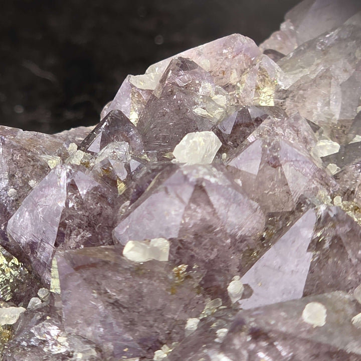 Embrace the raw beauty of nature with this unique Amethyst Geode Cluster. While it carries minor natural inclusions—perhaps hints of earthy hematite or other intriguing minerals—and some gentle signs of its journey, these features only add to its authenti