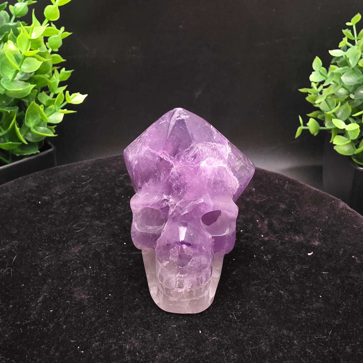Amethyst Hand Carved Crystal Skull Wand Point Sculpture - 2.5 Inch displayed with two carved skulls and crystal points.