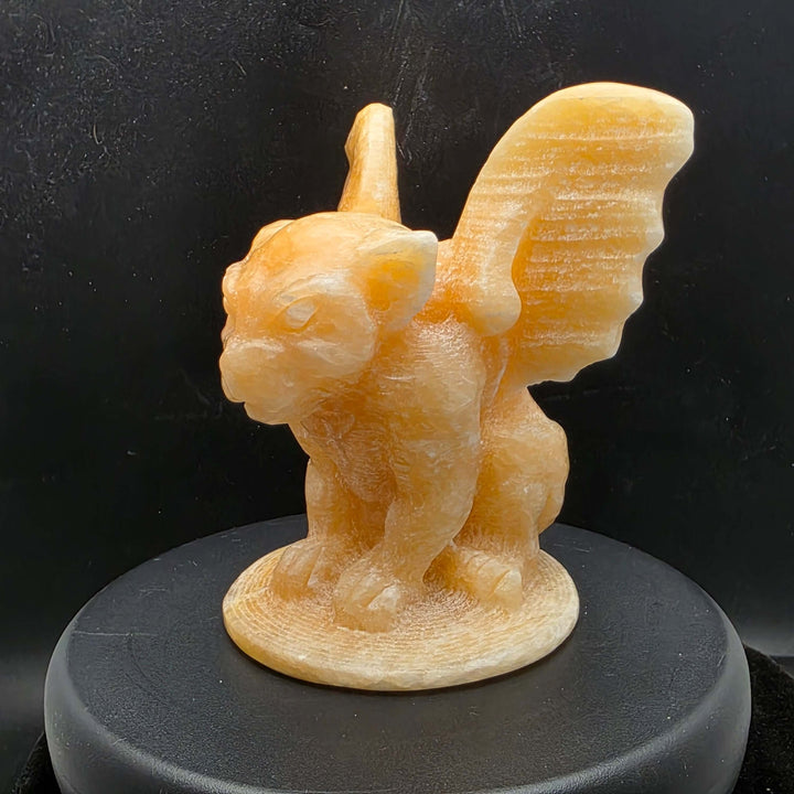 Yellow calcite gargoyle carving with wings relaxed, showcasing warm buttery yellow to honey-orange color.