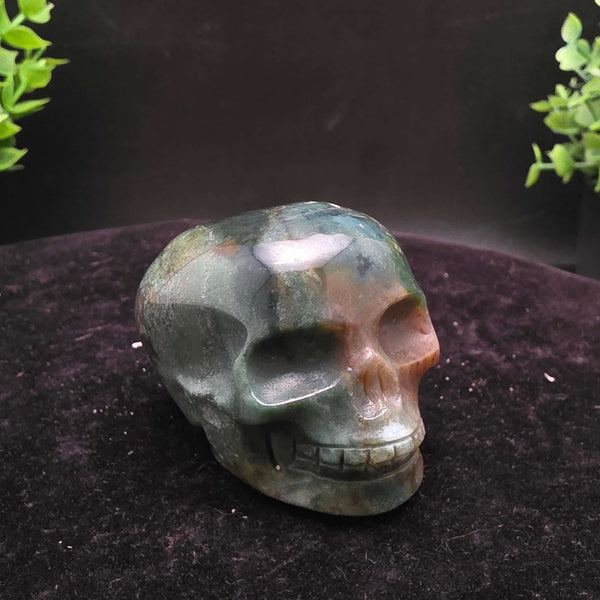 Orbicular Jasper Skull Carving - 2.25 Inch showcasing unique colors and textures on a dark background.