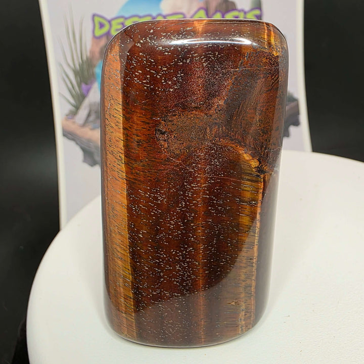 Polished Red Tiger's Eye freeform showcasing distinct reddish-brown hues and natural oxidation patterns.