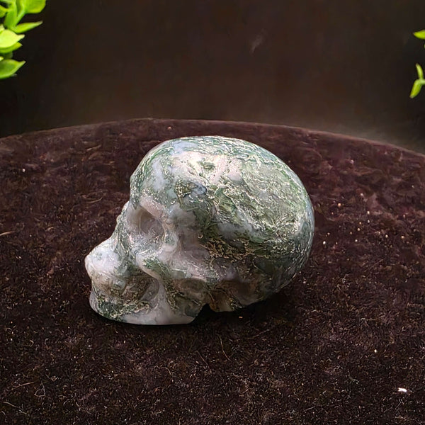 Moss Agate Skull Carving - 2 inch showcasing unique blue-green dendritic inclusions and frosty white matrix.