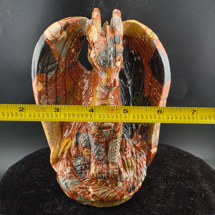 Jasper Sitting Dragon Carving, detailed stone sculpture in warm reds, oranges, and blacks, measuring over six inches tall.