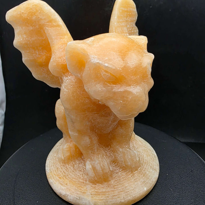Yellow calcite gargoyle carving with wings relaxed, showcasing warm buttery yellow to honey-orange color.
