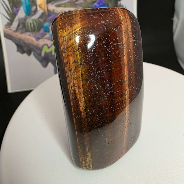 Polished Red Tiger's Eye freeform stone displaying reddish-brown colors and natural patterns.