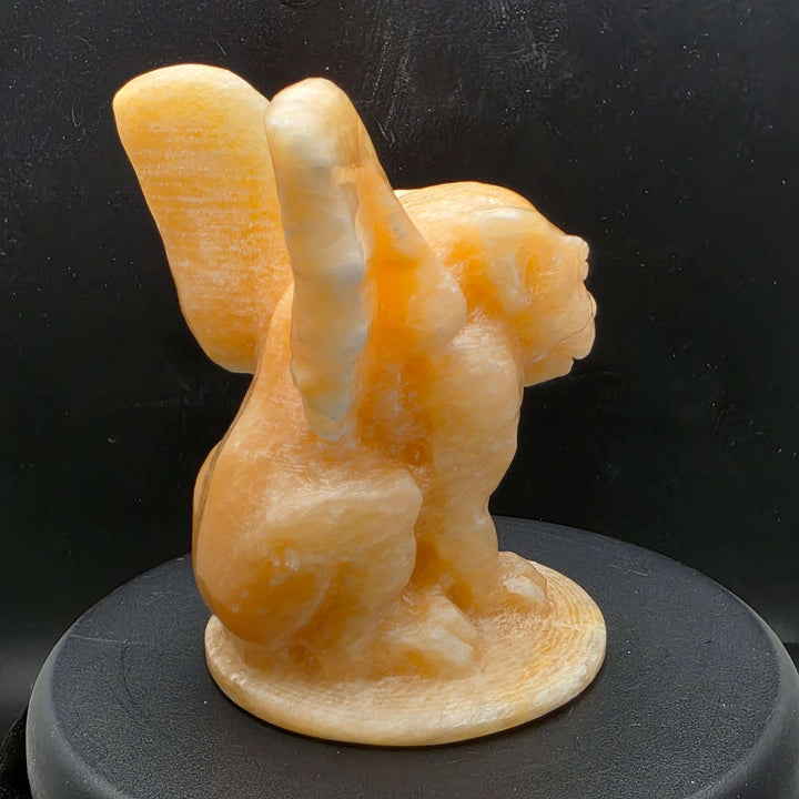 Yellow calcite gargoyle carving with wings relaxed, showcasing warm buttery yellow to honey-orange color.