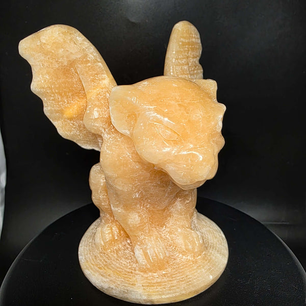 Yellow calcite gargoyle carving with wings relaxed, showcasing warm buttery yellow to honey-orange color.