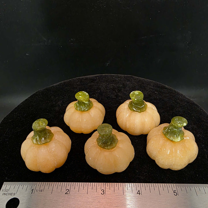 Set of five small Orange Calcite pumpkin carvings with green stems, perfect for display and decor.