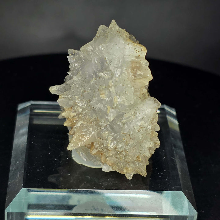 Calcite specimen from Guerrero, Mexico, displayed on a glass stand, showcasing unique geological features.