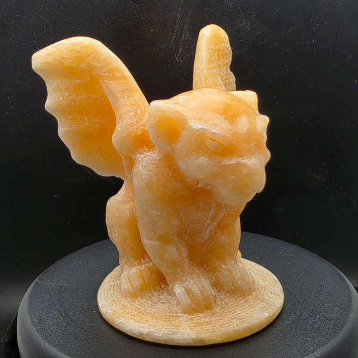 Yellow calcite gargoyle carving with wings relaxed, showcasing warm buttery yellow to honey-orange color.