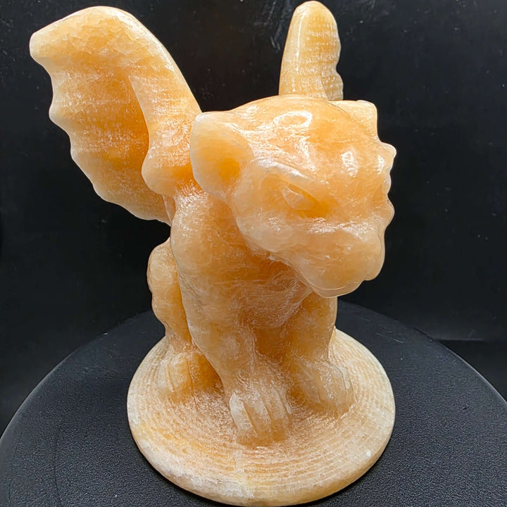 Yellow calcite gargoyle carving with wings relaxed, showcasing warm buttery yellow to honey-orange color.