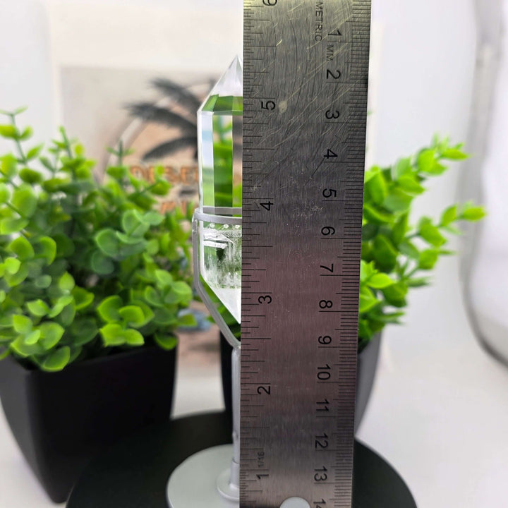  Polished Faceted Clear Quartz Crystal with Stand displayed among decorative plants.