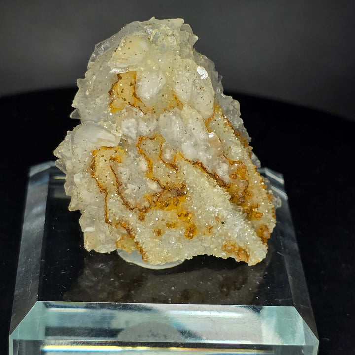 Calcite specimen from Guerrero, Mexico, displayed on a glass stand, showcasing unique three-generation growth patterns.