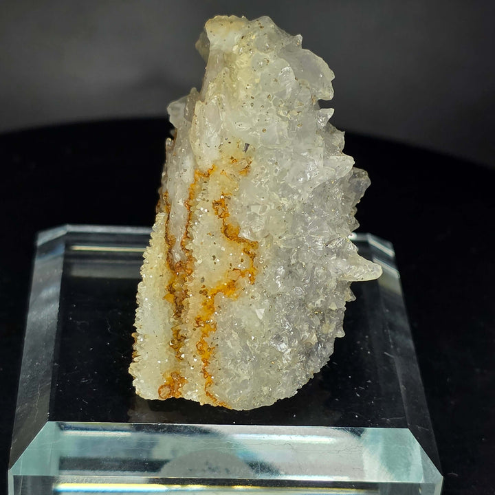 Calcite specimen from Guerrero, Mexico on glass display stand showcasing unique geological features.