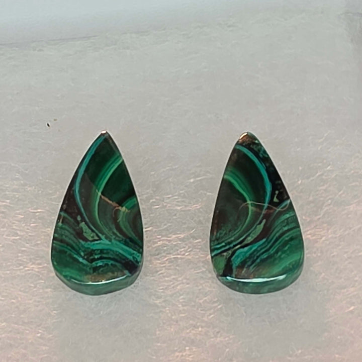 Bring the vibrant energy of nature into your home, or your next creative project, with our stunning Malachite Cabochon Pairs. Each pair features beautifully polished malachite, showcasing its unique swirling patterns, elegantly presented in a crisp white